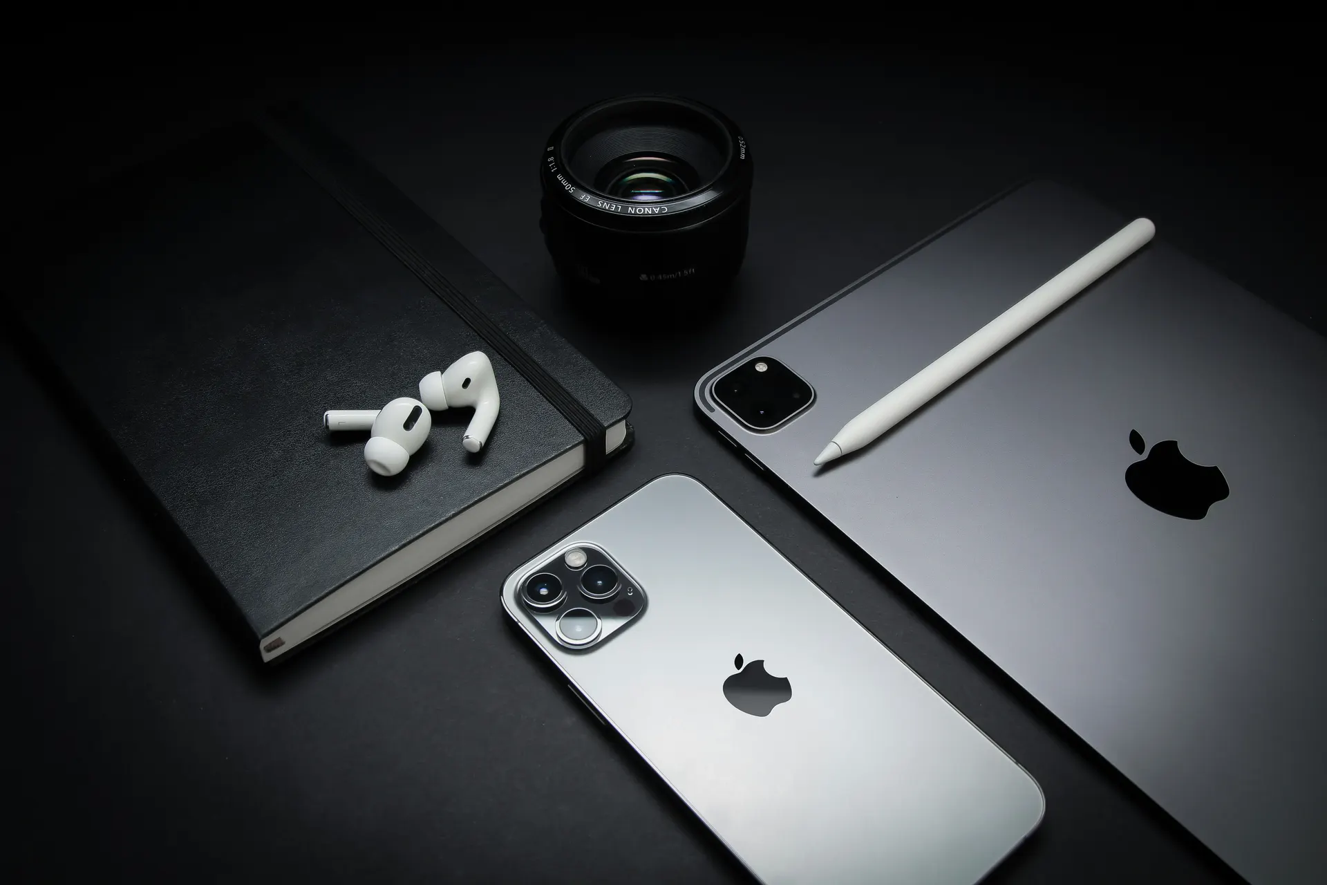 iPhone, iPad, AirPods e Apple Pencil sobre uma mesa escura, venda de aparelhos Apple em Curitiba